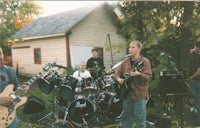 a group of people playing music in front of a house