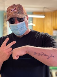 a man wearing a surgical mask with a tattoo on his face