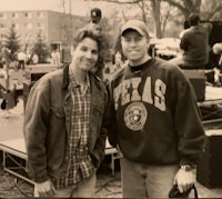 two men standing next to each other at an outdoor event